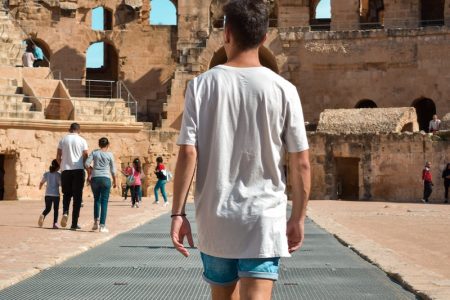 Photo d'un homme dans l'ancien amphithéâtre romain à El Jem, Tunisie