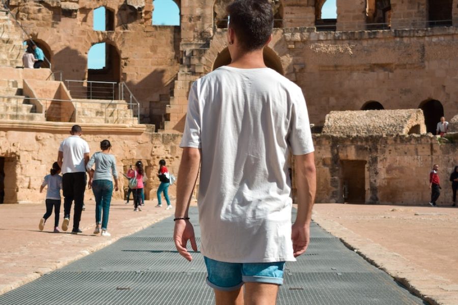 Photo d'un homme dans l'ancien amphithéâtre romain à El Jem, Tunisie