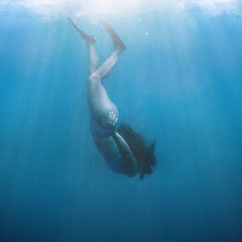 a man swimming in the ocean under water